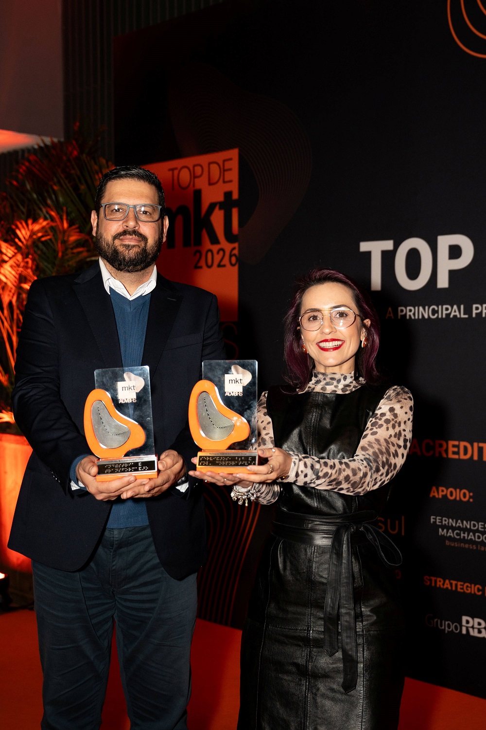 Turiassu Araújo (E) e Adriana Angar, respectivamente, consultor e coordenadora de marketing da Marcopolo,  recebem as premiações nas categorias "Indústria & Transformação Produtiva" e "Serviços, B2B & Soluções Corporativas".